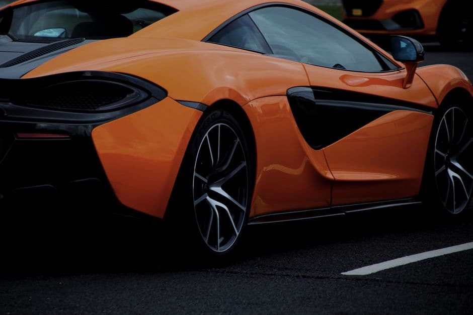 Coche deportivo naranja a alta velocidad en carretera, en la sala de chat de Fórmula 1