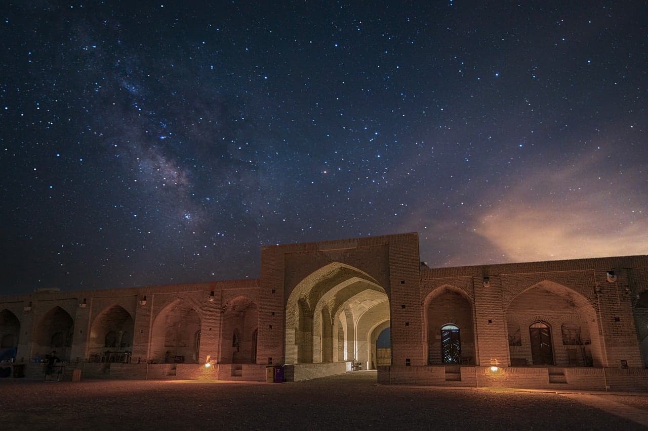 Cielo nocturno estrellado con telescopio apuntando al horizonte, en la sala de chat de Astronomía