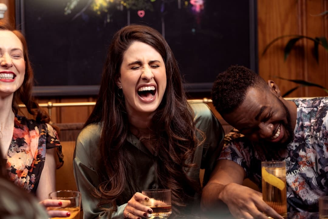 Gente sonriendo alrededor de una mesa con bebidas en la sala de chat de Memes