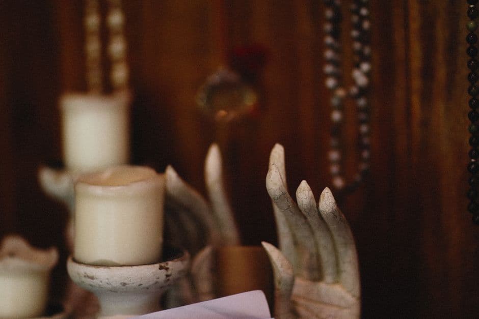 Esculturas de manos macabras rodeadas de velas encendidas, en la sala de chat de Debate religioso