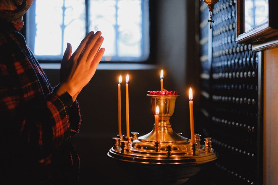 Veladoras y manos unidas en oración, en la sala de chat de Espiritualidad