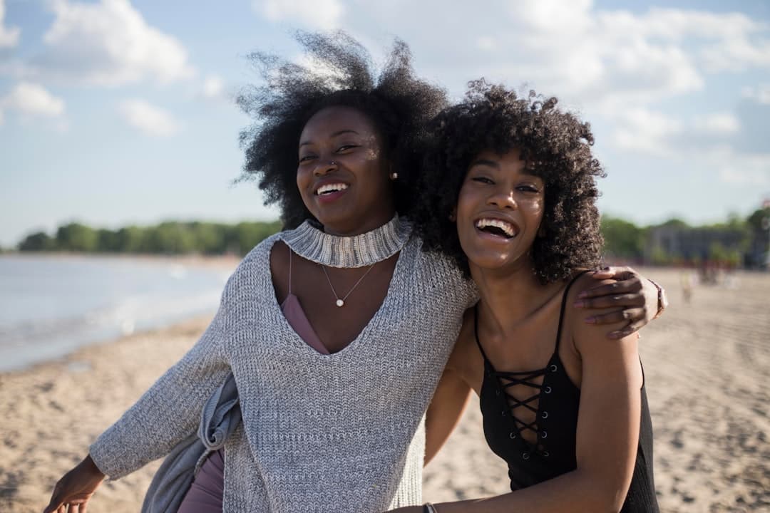 Dos mujeres ríen juntas junto al mar, en la sala de chat de Sudcalifornianos