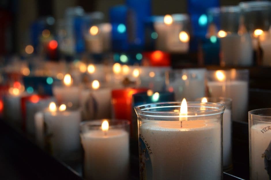 Velas encendidas alineadas en la nave de una iglesia, en la sala de chat de Ungidos