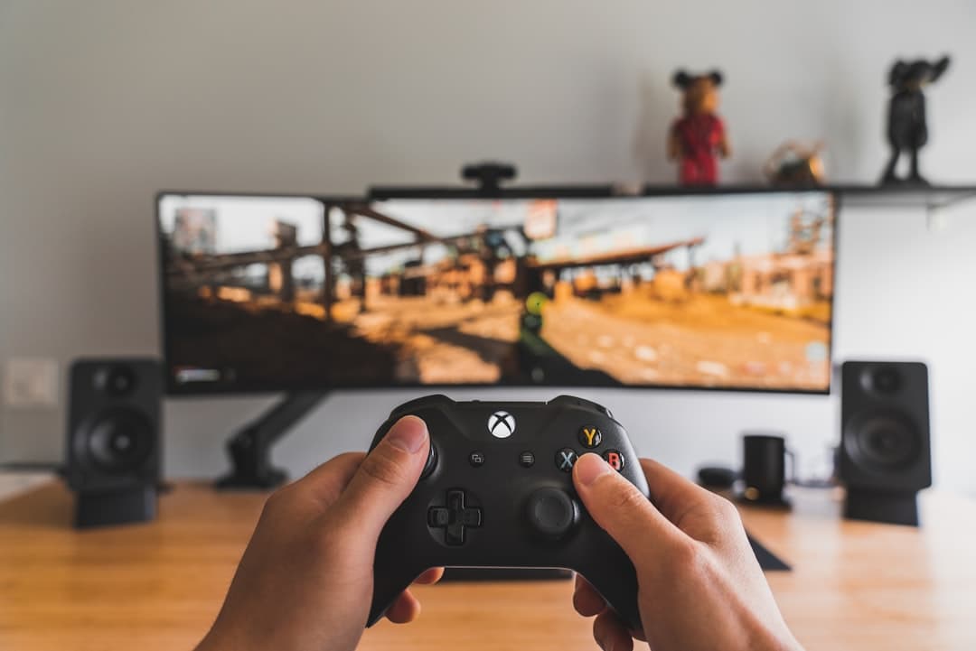 Mano sosteniendo un controlador de videojuegos negro, en la sala de chat de Hollow Knight