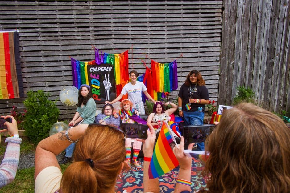 Grupo de personas sosteniendo banderas arcoíris y de orgullo, en la sala de chat de Bisexuales