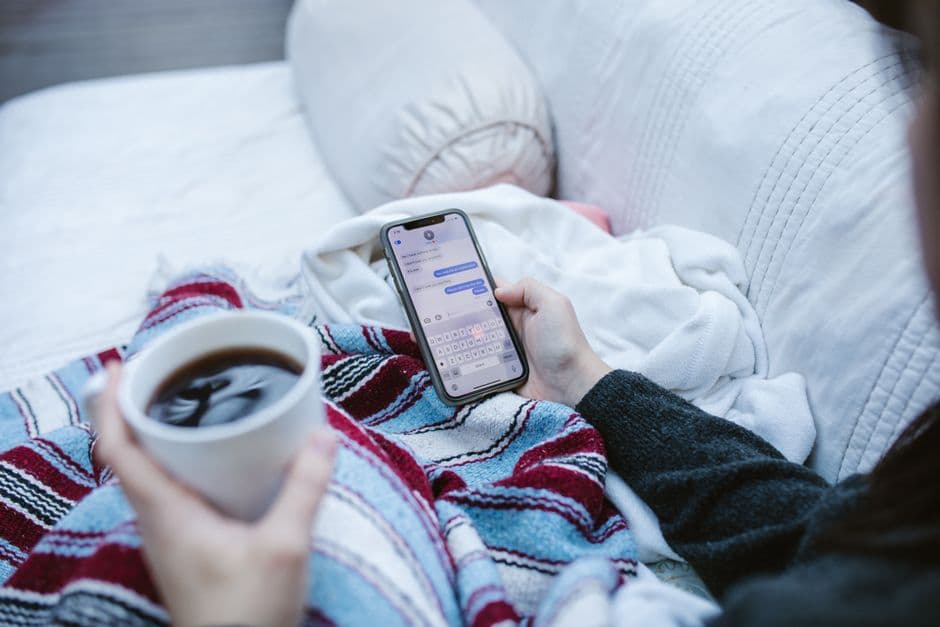Taza de café sobre mesa, smartphone al lado, ambiente relajado, en el chat de Telegram Gay