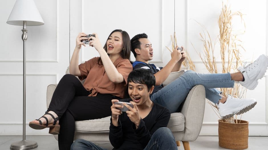Amigos multiculturales juegan un juego móvil, en la sala de chat de Telegram Parejas
