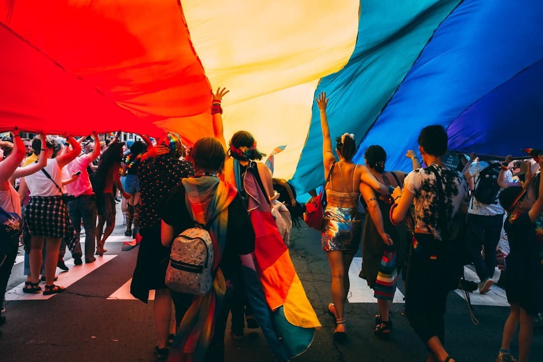 Grupo de personas bajo bandera arcoíris del orgullo en el chat de Chueca Sitges