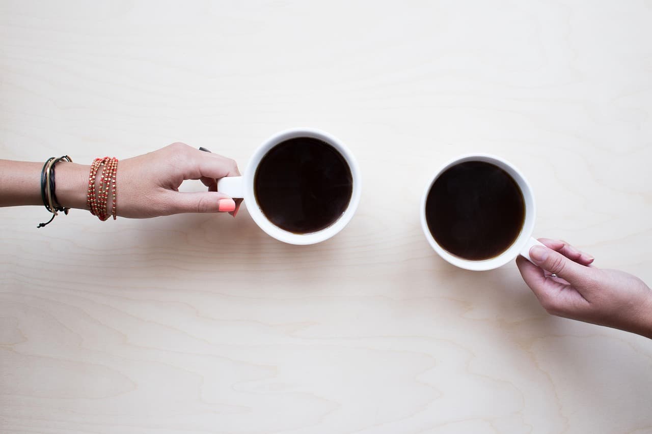Grupo de amigos riéndose mientras toman café y charlan, en la sala de chat de Undernet