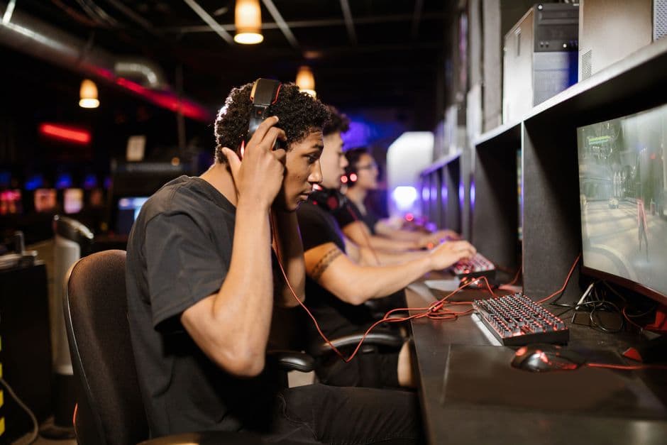Grupo de hombres jugando videojuegos en computadoras, en la sala de chat de Chatsi