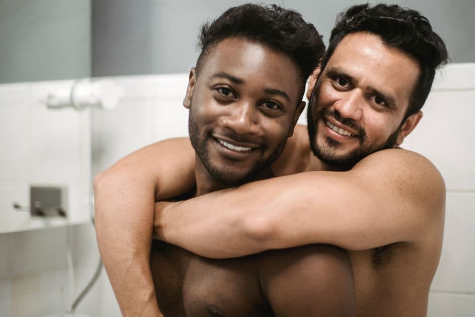Hombres sonrientes sentados en una bañera, en la sala de chat de Chueca Canarias
