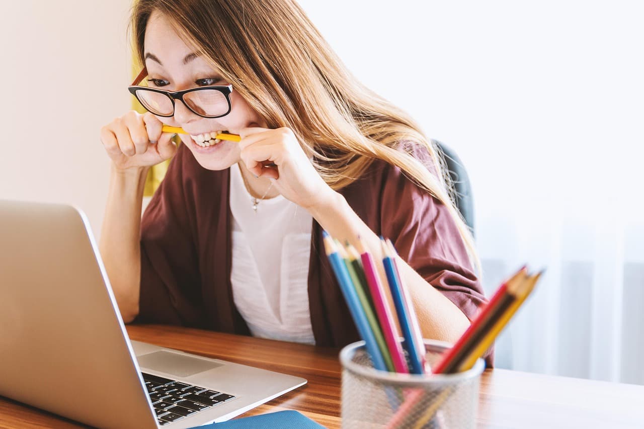Mujer joven estudiando con una laptop, en la sala de chat de Chat en Español