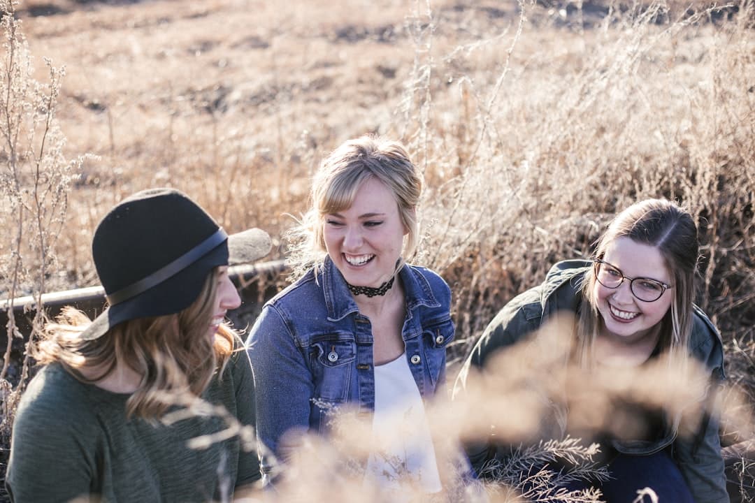 Tres mujeres riendo mientras posan para una foto grupal, en el chat de Guatemalteco