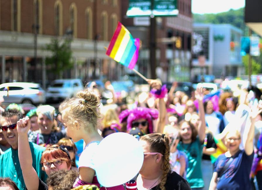 Gente desfilando con banderas arcoíris, en la sala de chat de LGBTQ+