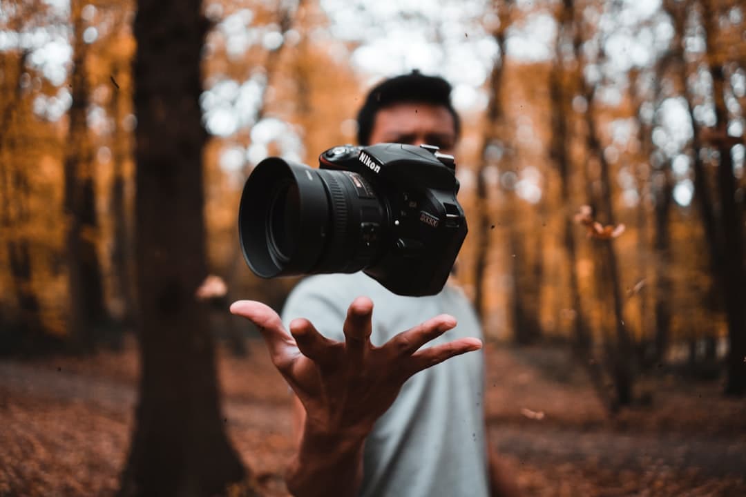 Cámara DSLR negra sobre mano en bosque, en la sala de chat de Fotografía