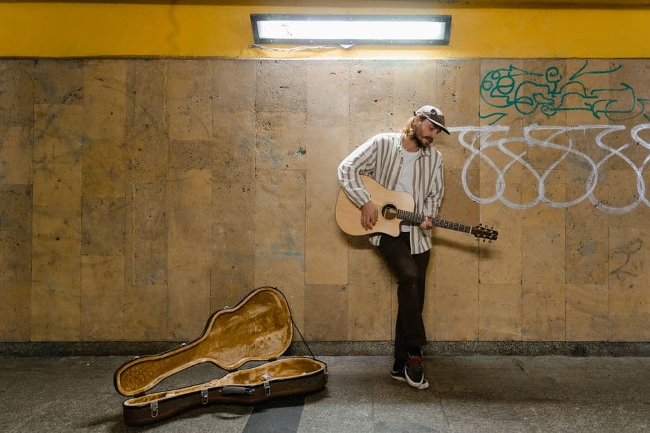 Un hombre tocando una guitarra acústica marrón