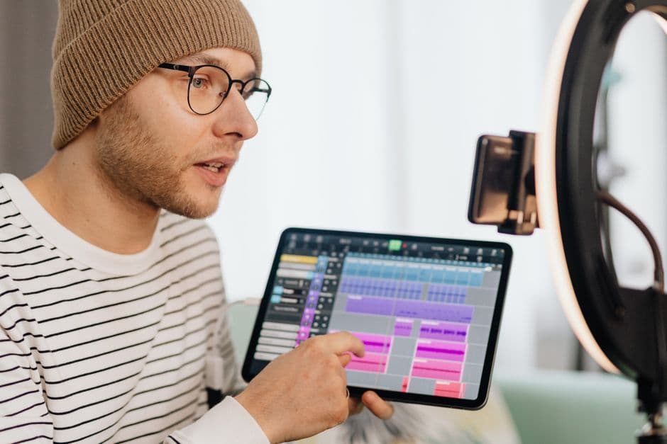 Un hombre grabando vídeo de creación de música con tableta