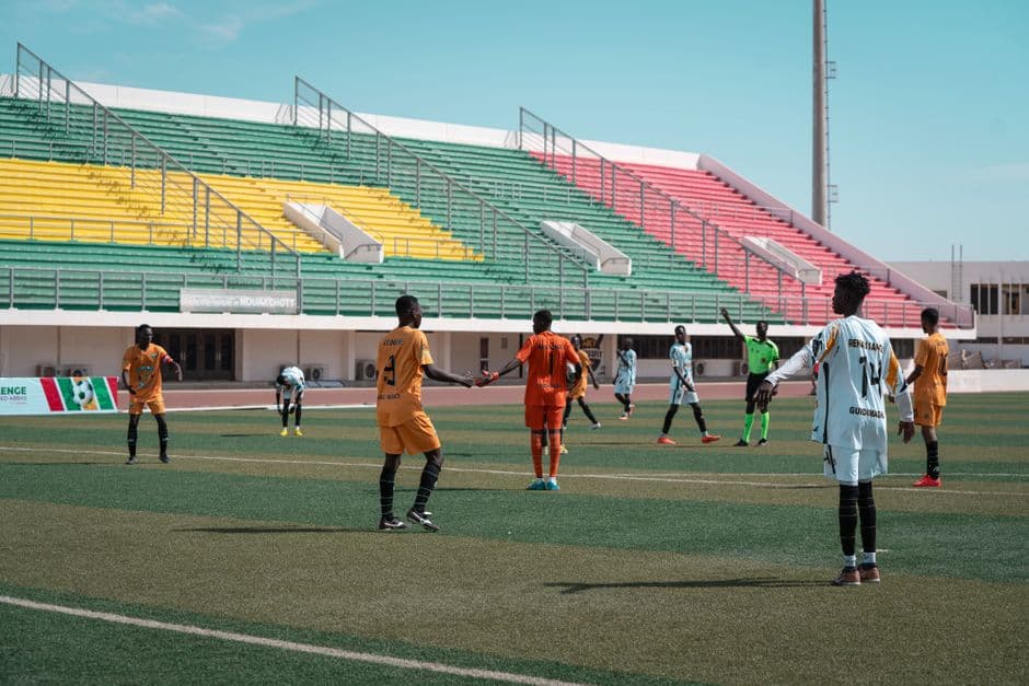 Hombres jugando fútbol en un estadio vacío