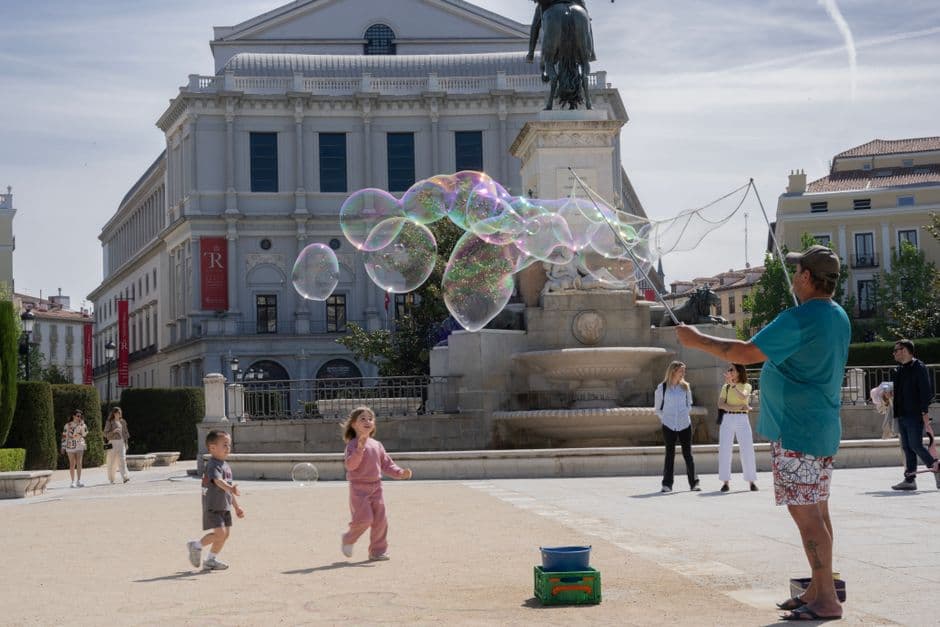 Niños jugando con burbujas en una plaza de la ciudad