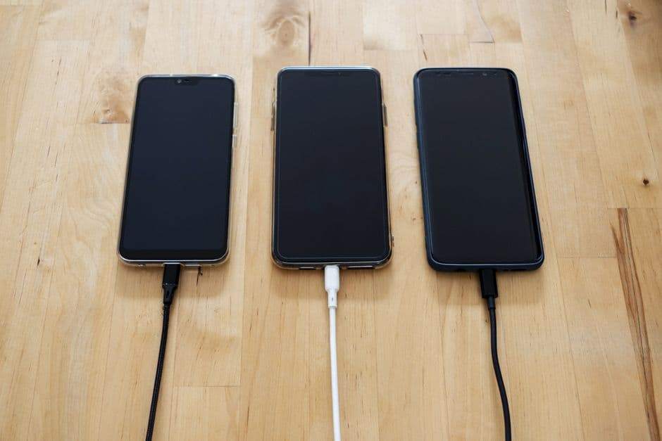 Teléfono android negro sobre superficie de madera, en la sala de chat de El orden correcto para cargar tu teléfono
