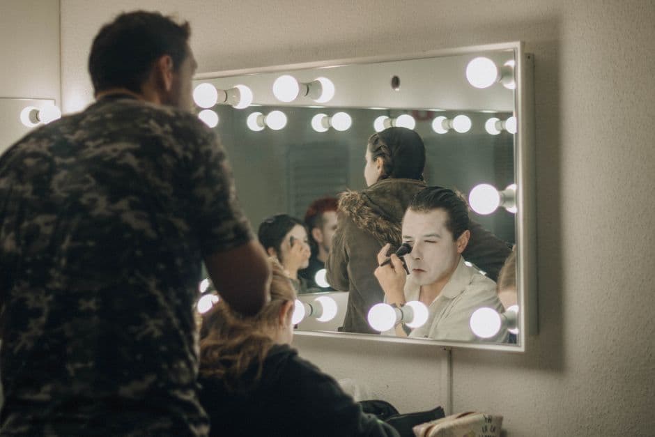 Maquillaje aplicado entre bambalinas en un camerino