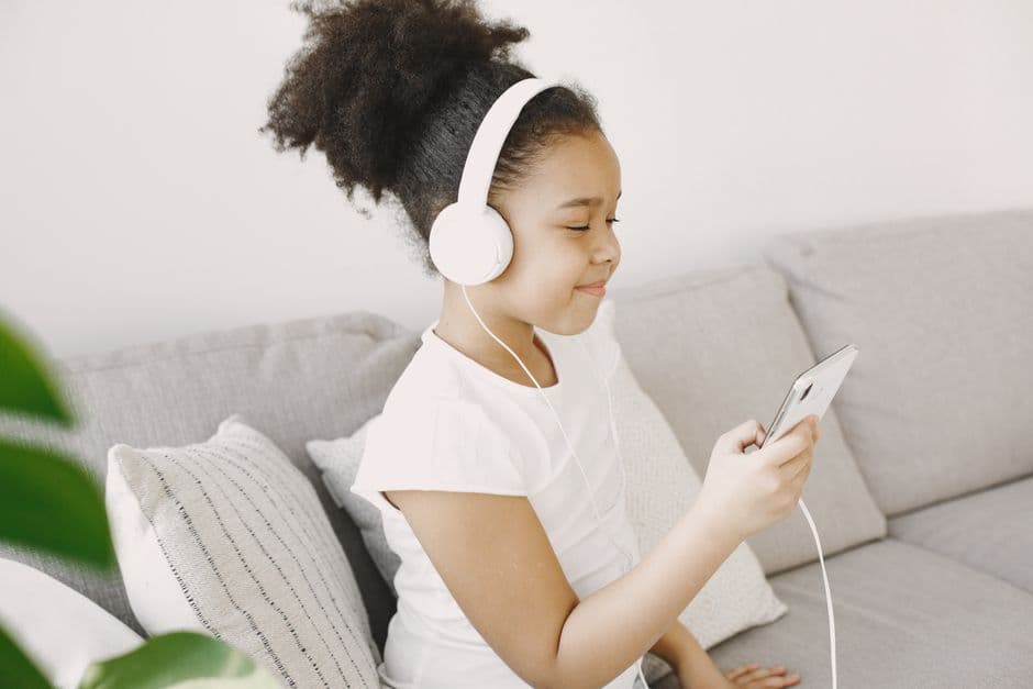 Una niña escuchando música con su teléfono móvil