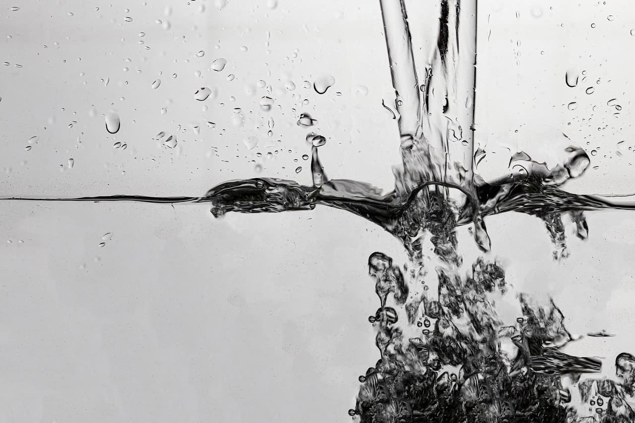 Burbujas y gotas de agua en movimiento sobre un líquido