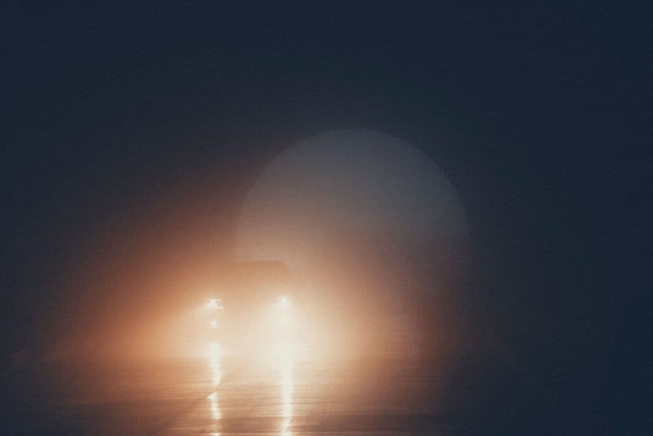 Un coche circulando por un túnel con niebla de noche