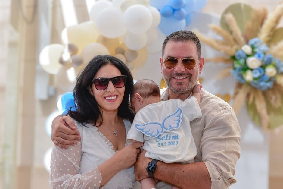 Una familia con un bebé vestido de blanco