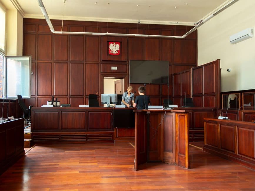 Interior de una sala de tribunal con bancadas de madera