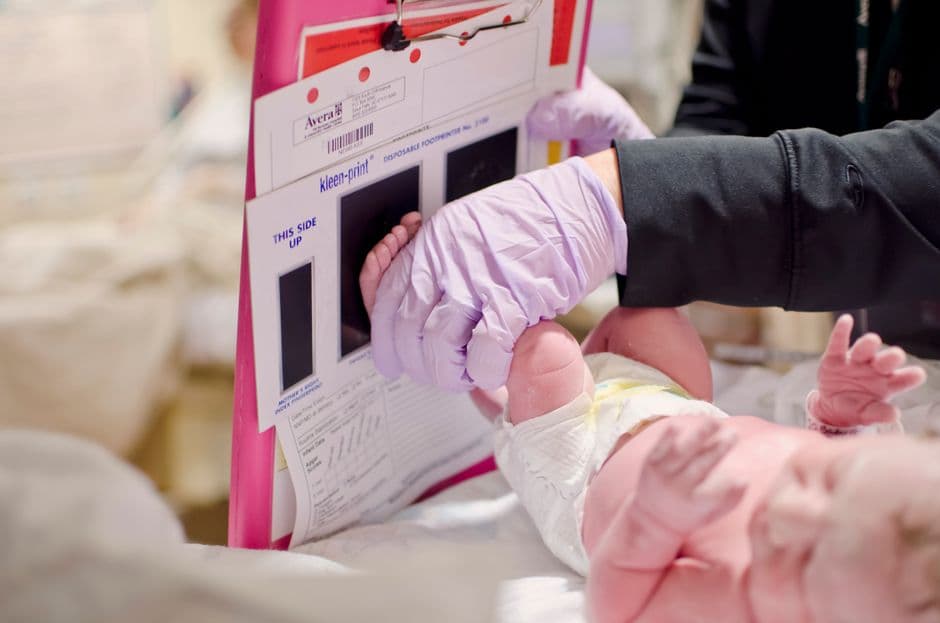 Persona sosteniendo un bebé en sus brazos con ternura