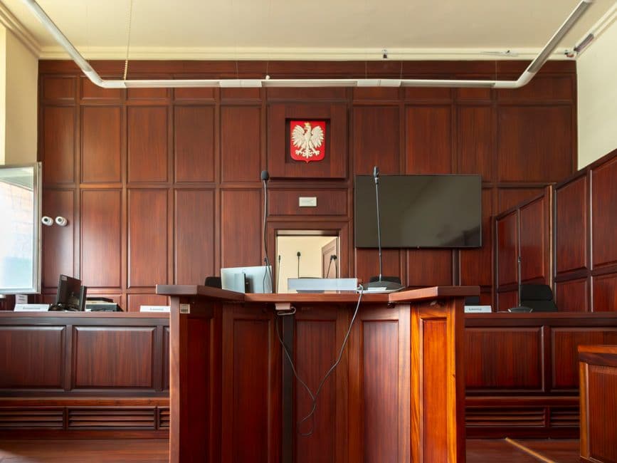 Interior de una majestuosa sala de tribunales con bancos de madera