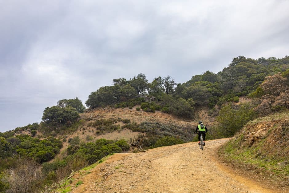 Persona pedaleando en una bicicleta montañosa entre montañas