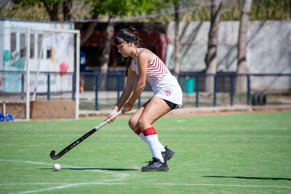 Jugadora de hockey en acción jugando al aire libre en cancha