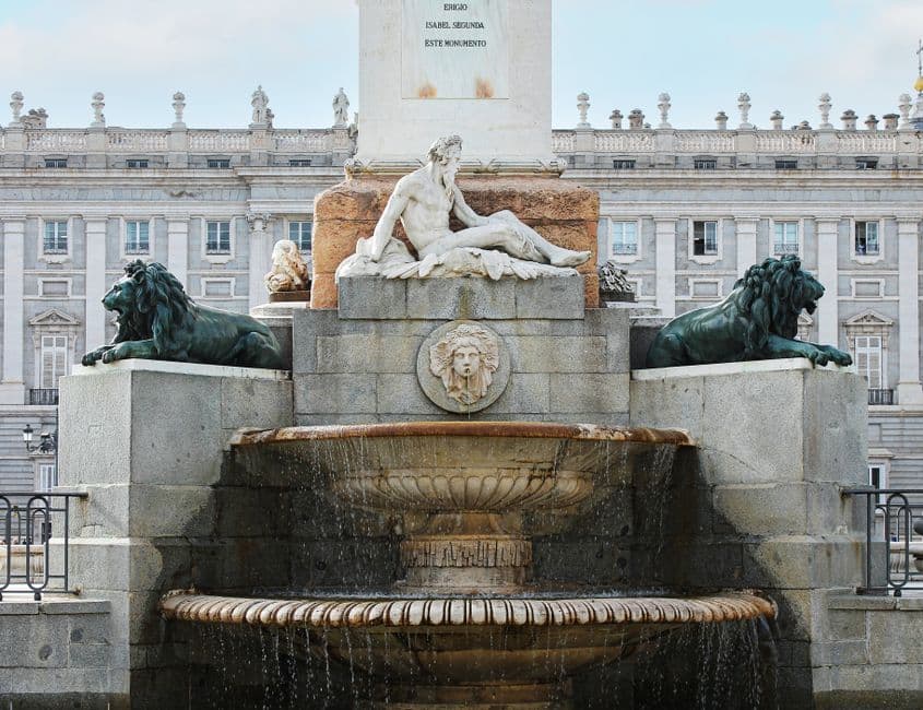Una escultura de arte clásico frente a un palacio