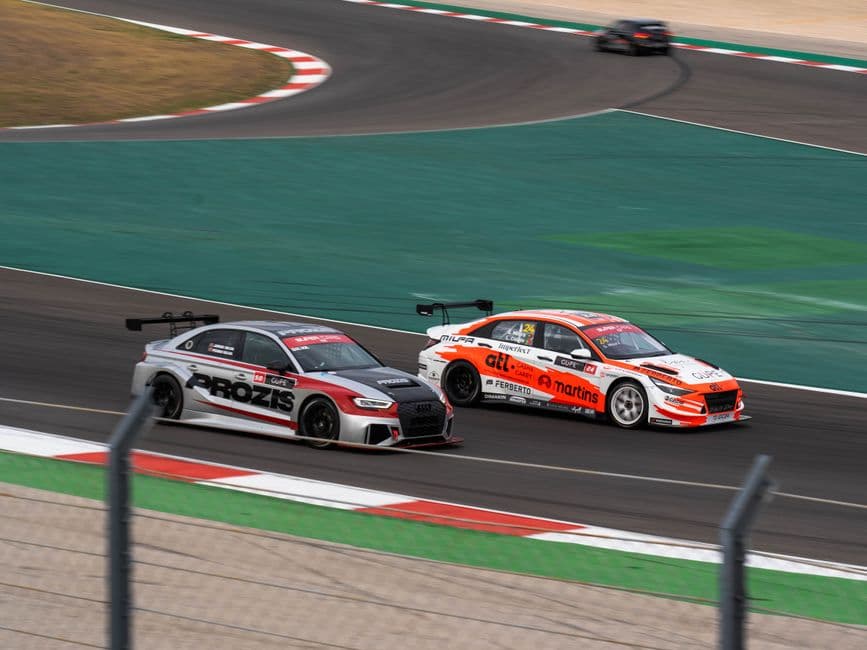 Autos de carrera a alta velocidad en una pista de competición