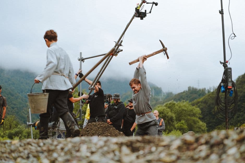 Actores y equipo de filmación trabajando en un escenario montañoso