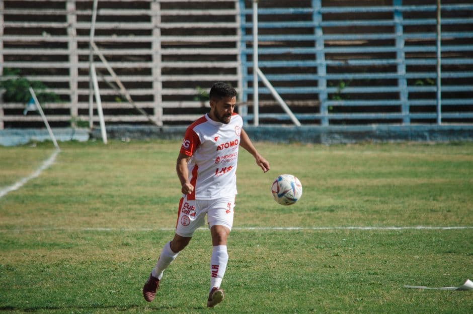 Hombre jugando fútbol en un campo o estadio