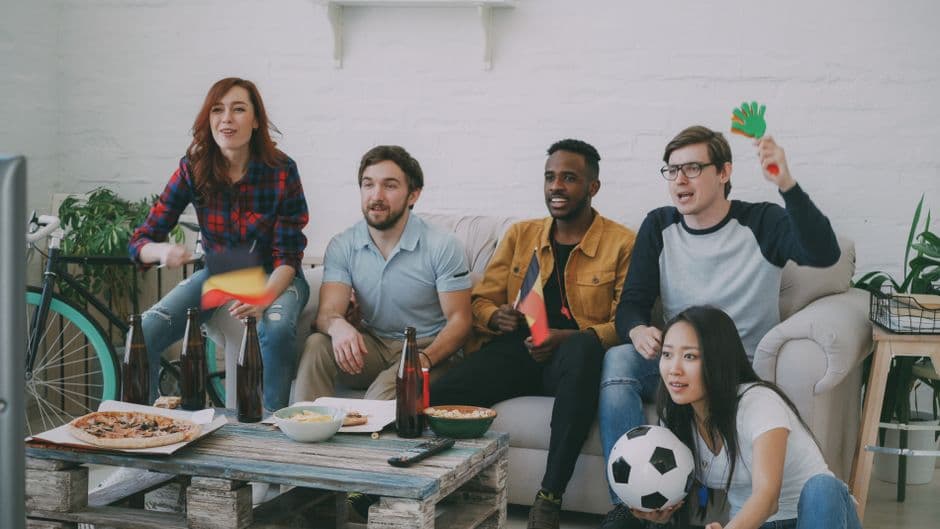 Grupo diverso disfrutando un partido de fútbol en interior
