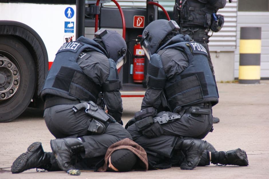 Vista trasera de policías deteniendo a un sospechoso