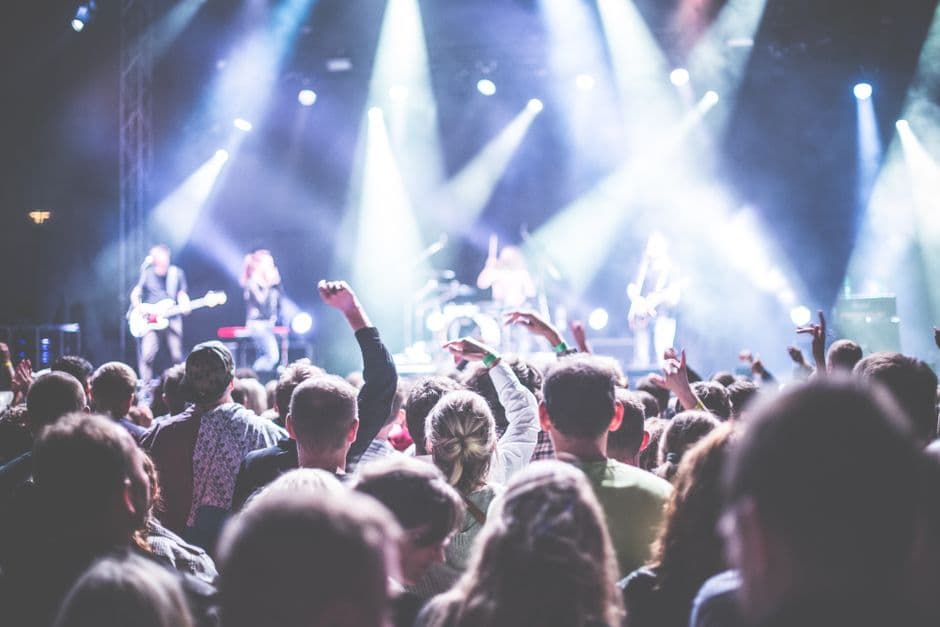 Multitud viendo una actuación musical en vivo por la noche