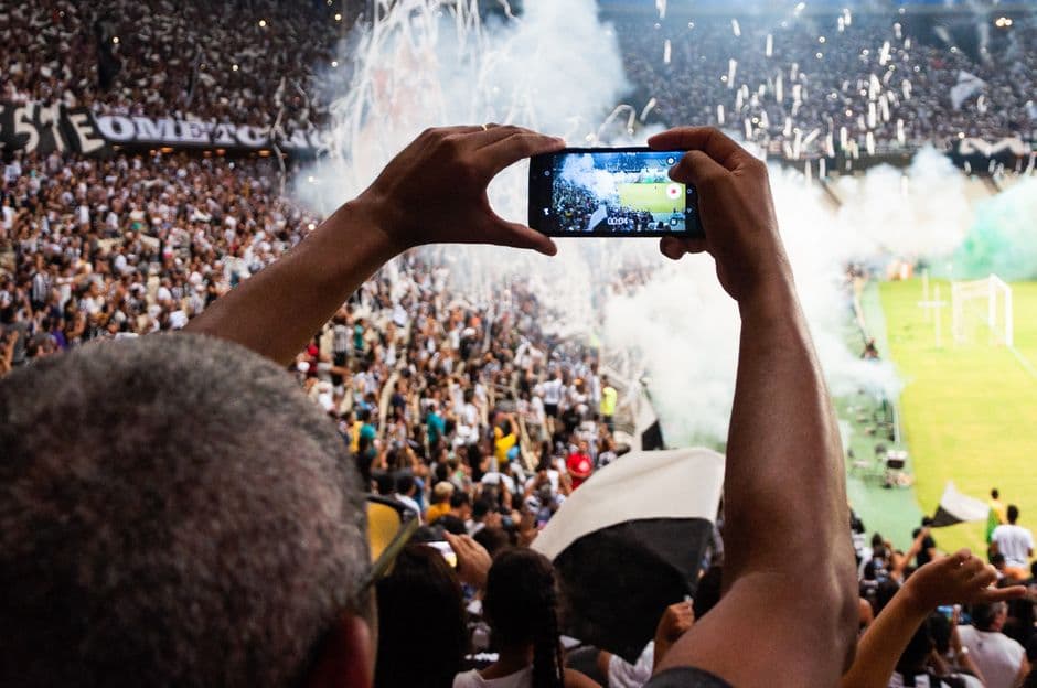 Una persona fotografiando un escenario en un estadio