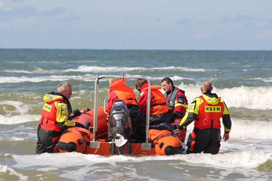 Grupo de salvavidas en el agua con un bote de rescate
