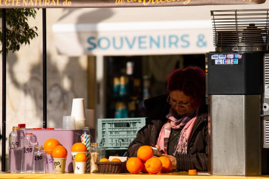 Mujer vendiendo jugo de naranja fresco en la calle de la ciudad