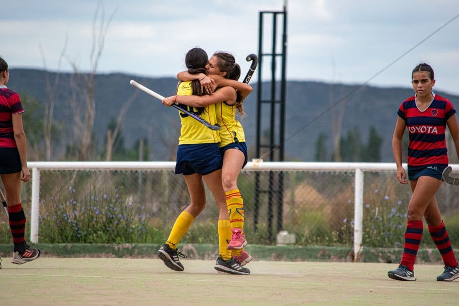 Jóvenes jugadoras de hockey celebrando su victoria juntas