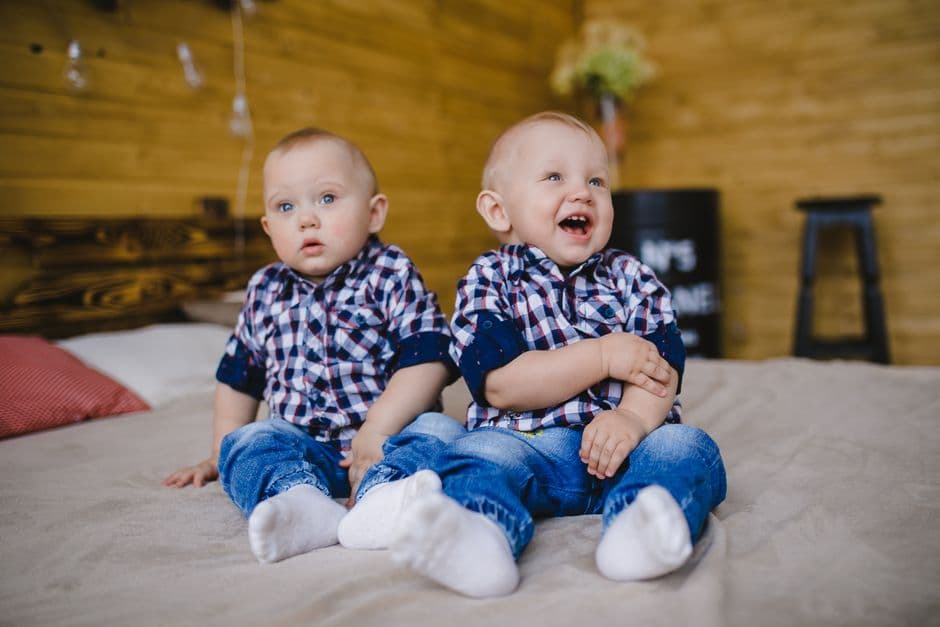 Dos niños pequeños sentados juntos en una cama