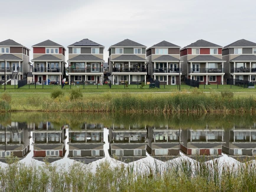 Fila de casas modernas reflejadas perfectamente en agua