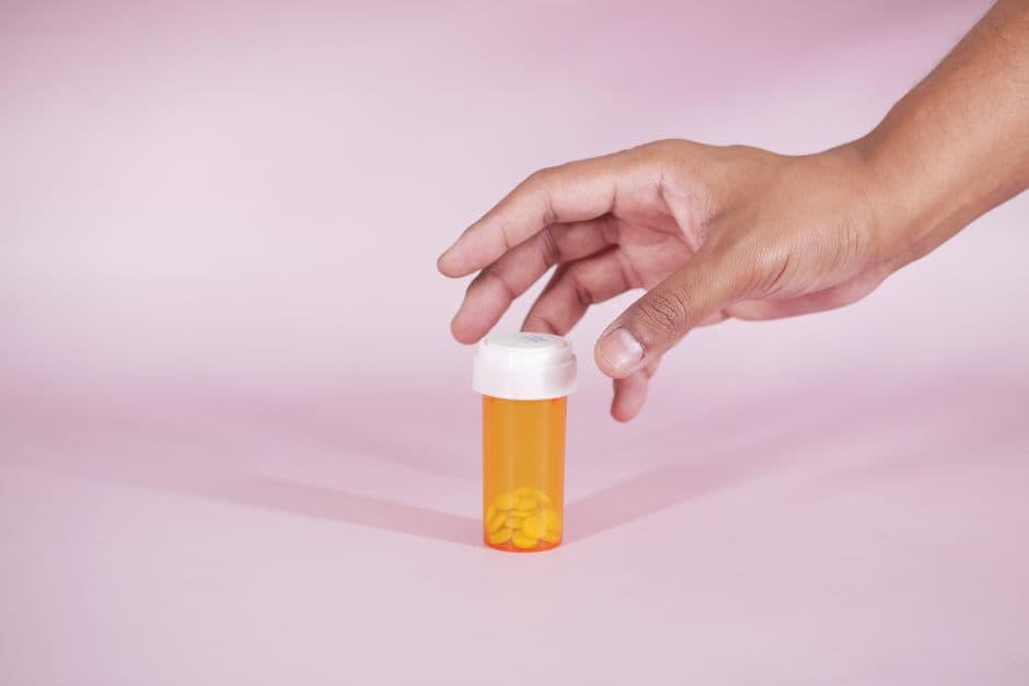 Persona alcanzando un frasco de medicina en botiquín