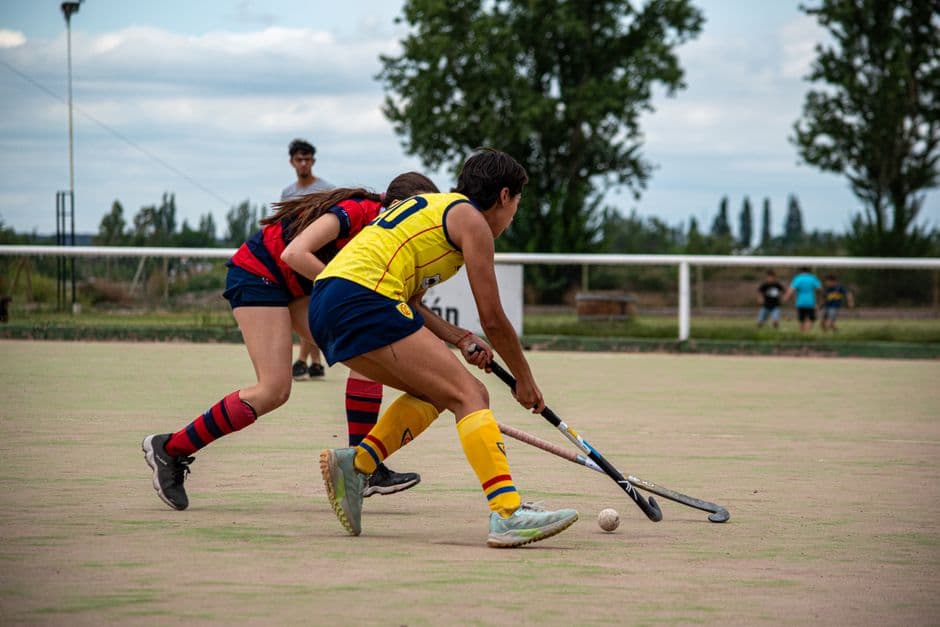 Partido de hockey femenino jugándose al aire libre