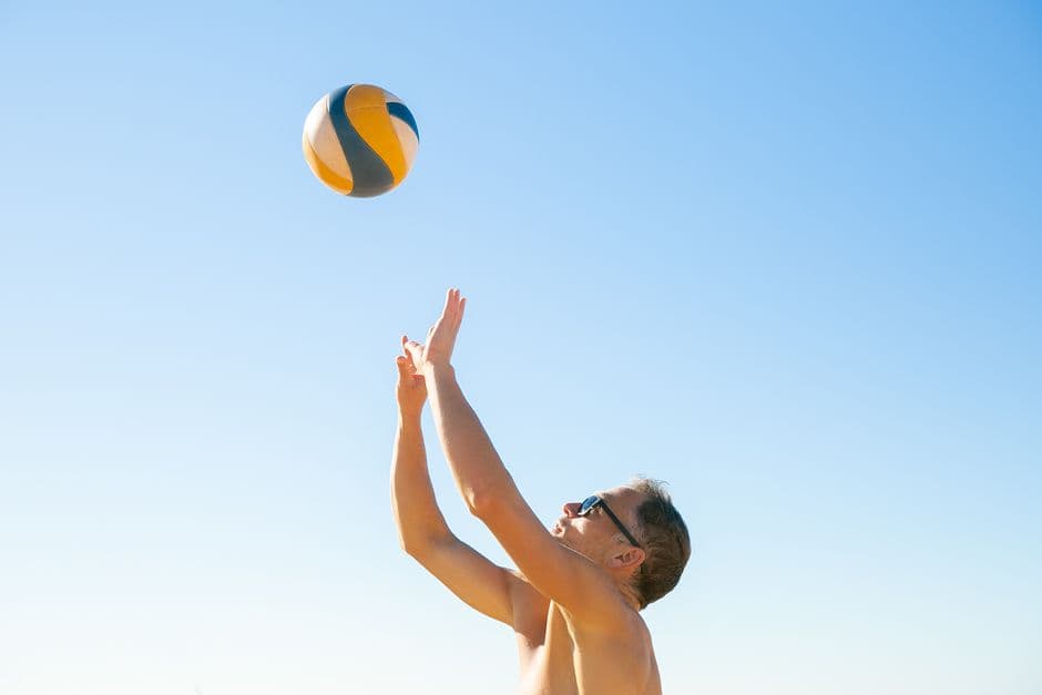 Hombre jugando voleibol en una cancha al aire libre